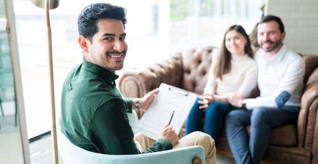 Confident,Young,Psychologist,With,Couple,In,Background,During,Consultation,In Confident,Young,Psychologist,With,Couple,In,Background,During,Consultation,In